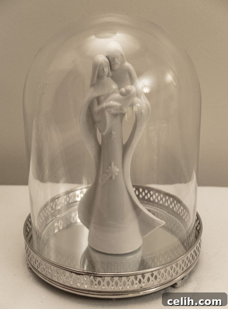 Christmas nativity decoration in white under a glass bell jar