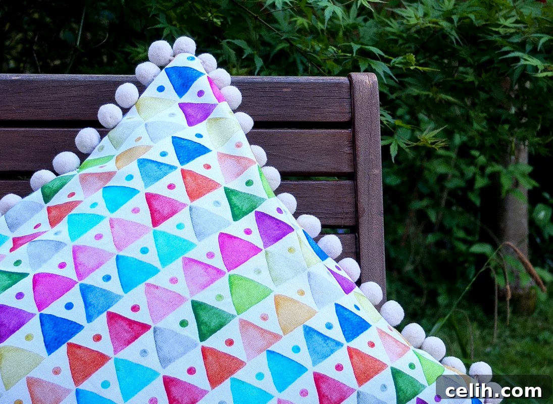Sip in Style: Dekoria's Contemporary Garden Escape 4 Admire this stunning, colorful and contemporary geometric triangle design cushion, perfectly accented by charming pompoms