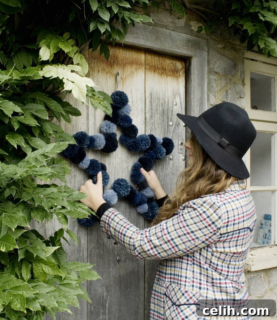 Deck the Halls with Amazing Christmas Wreath Hanging Ideas 2 Handmade star-shaped Christmas wreath crafted from large, fluffy pom poms, available in various sizes and contemporary colors from white to vibrant shades. Perfect for a modern and playful holiday decor.