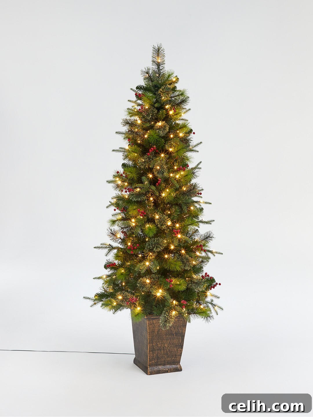 Use this potted berry and pinecone Christmas tree to decorate outside your front door for Christmas, creating a classic festive look