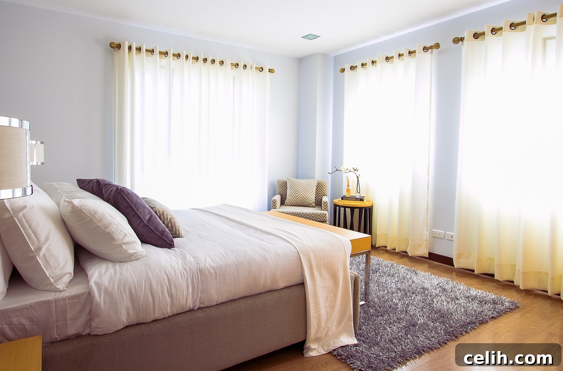A bedroom with sheer white curtains allowing natural light to filter through.